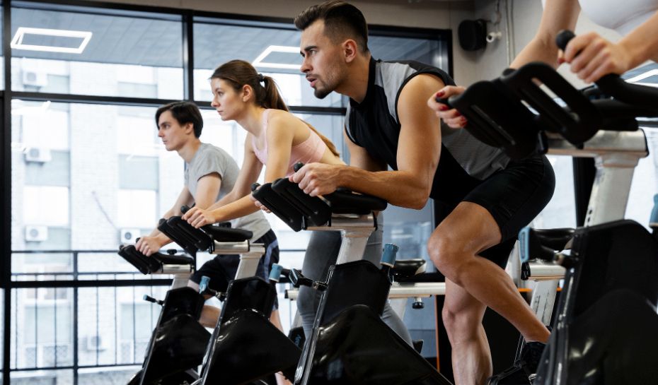 Gente en el gimnasio haciendo bicicleta fija